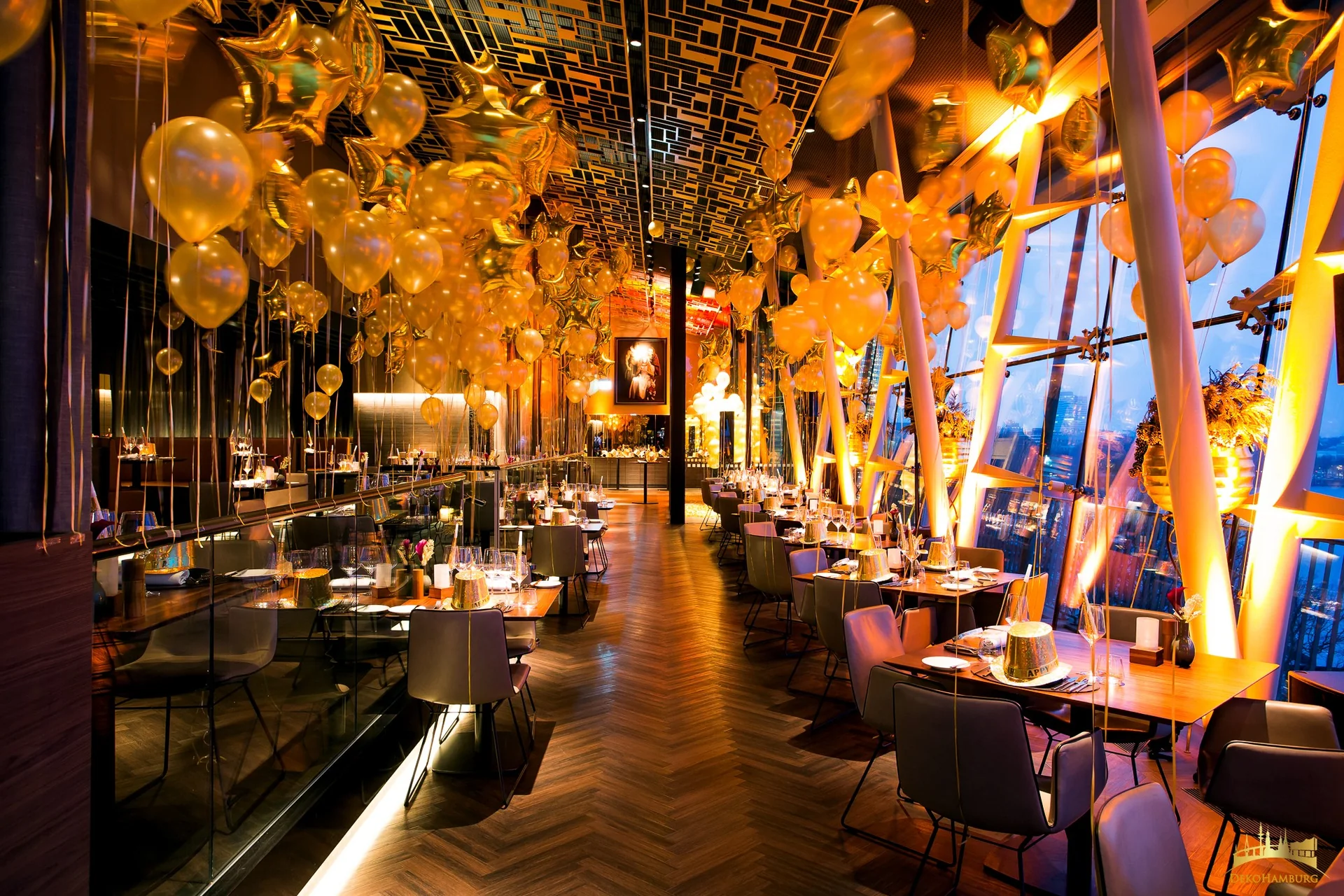 Goldene Ballons über festlich gedeckten Tischen in einem Restaurant